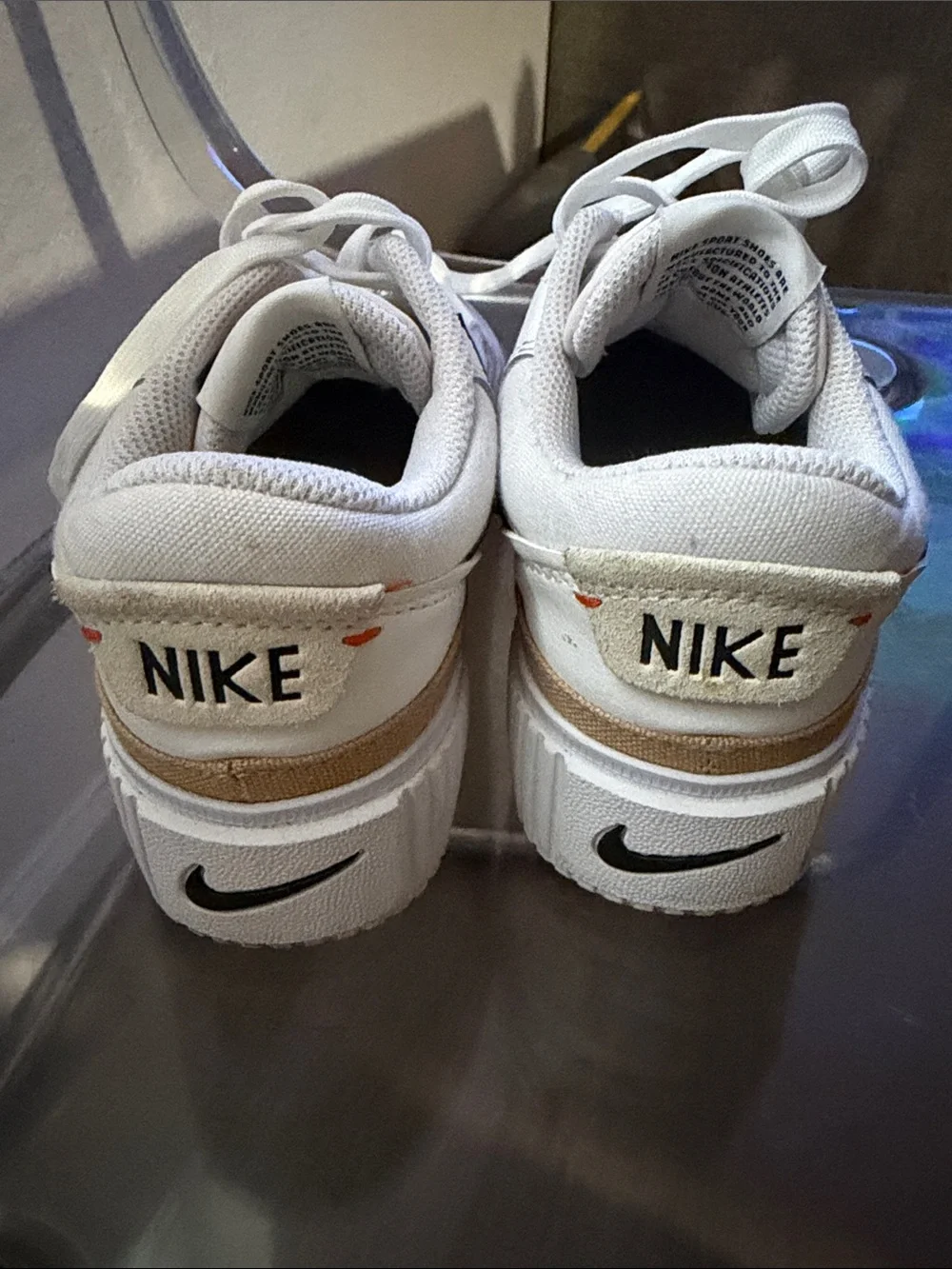 Nike White Low-Top Sneakers with Black Swoosh and Tan Accent